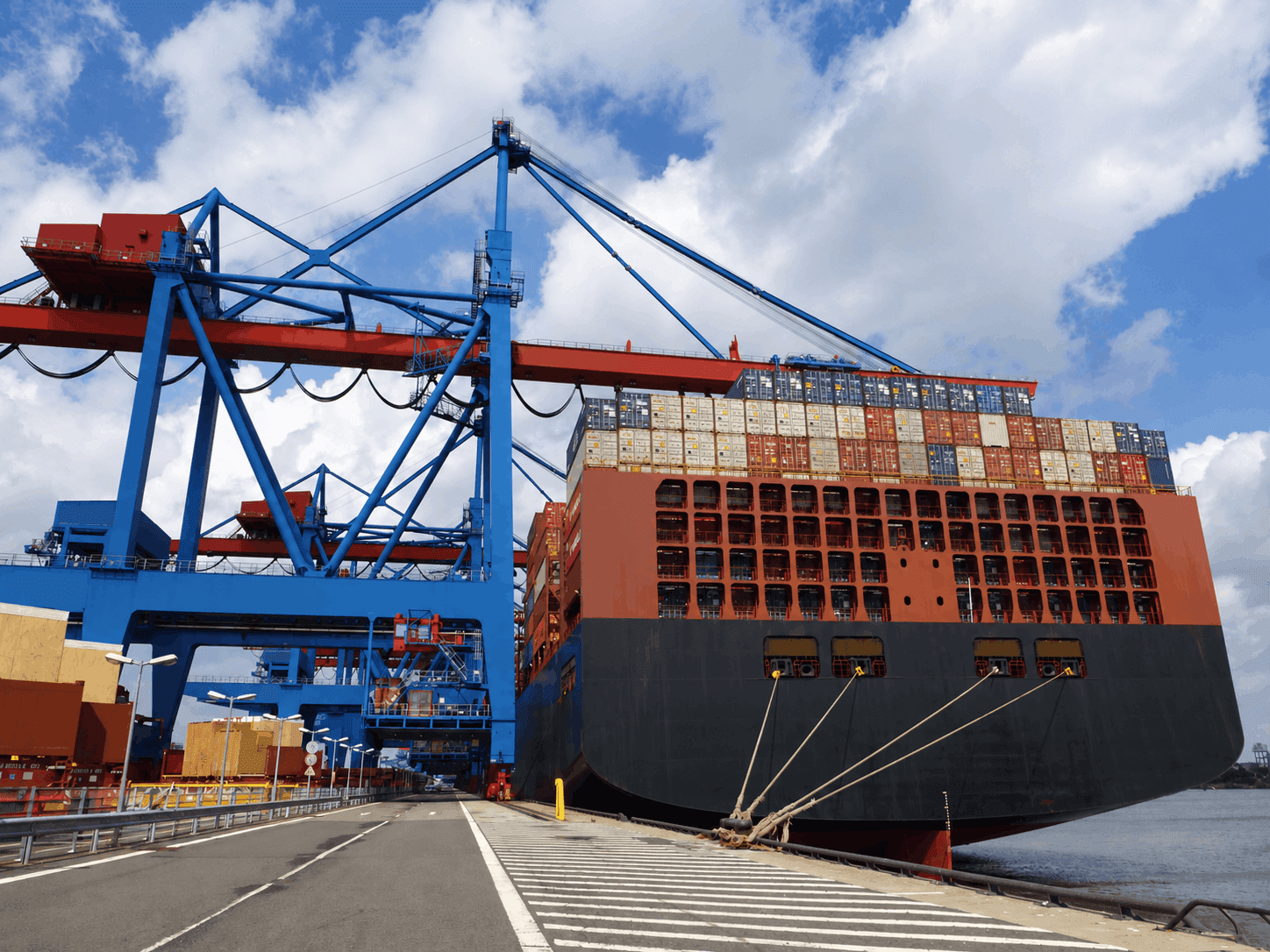 Cargo ship at the port beside container cranes